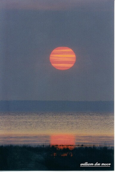 Photo of sunrise over the bay by Bill Moor (2004) at Mackinaw Mill Creek Camping in Mackinaw City, MI.