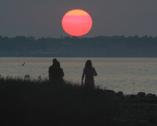 Photo of campers in the glow of sunset by Melissa Meyers at Mackinaw Mill Creek Camping in Mackinaw City, MI.