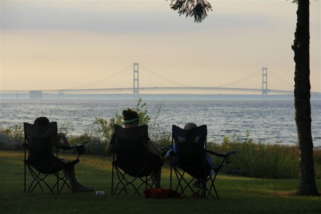 Photo of camper reading in view of the Mackinac Bridge at Mackinaw Mill Creek Camping in Mackinaw City, MI. © 2016 Frank Rogala.