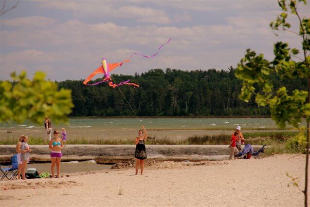 Photo of campers flying kites on the sandy beach of Mackinaw Mill Creek Camping in Mackinaw City, MI. © 2016 Frank Rogala.
