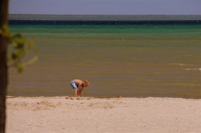 Photo of child playing on the sandy beach of Lake Huron at Mackinaw Mill Creek Camping in Mackinaw City, MI. © 2016 Frank Rogala.