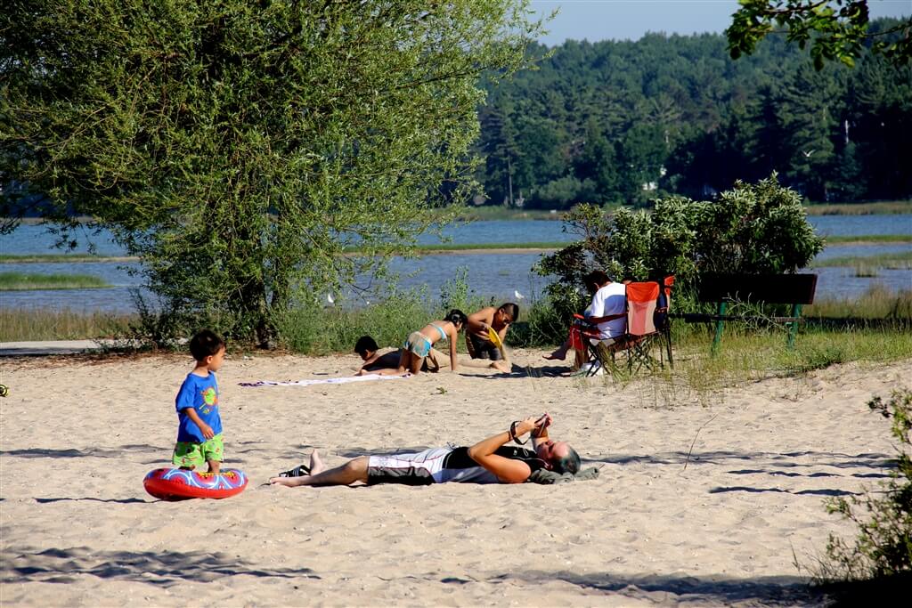 Photo of campers sunbathing on the sandy beaches of Mackinaw Mill Creek Camping in Mackinaw City, MI. © 2016 Frank Rogala.