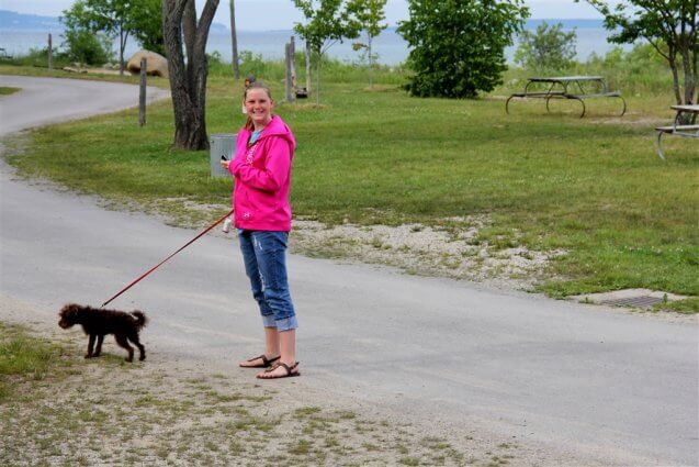 Photo of camper walking her dog on Cadottes Point at Mackinaw Mill Creek Camping in Mackinaw City, MI. © 2016 Frank Rogala.