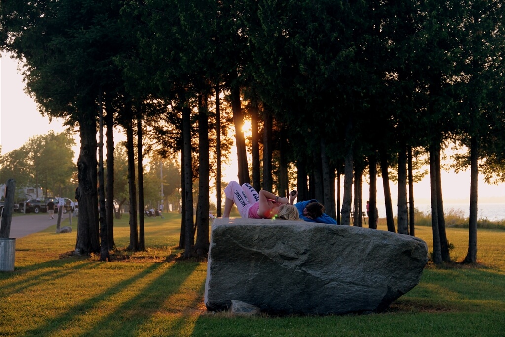 Photo of campers relaxing on a boulder at sunset at Mackinaw Mill Creek Camping in Mackinaw City, MI. © 2016 Frank Rogala.